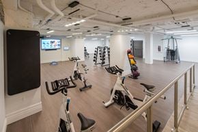 Washington apartment for rent - A gym with exercise equipment and a television on the wall.