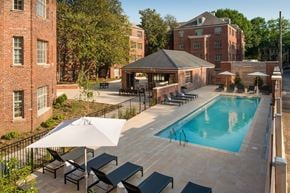 Washington apartment for rent - A pool area with a white umbrella and black lounge chairs.