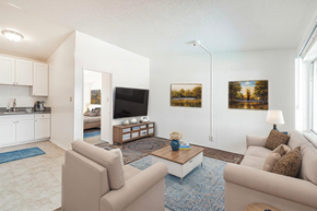 Downey multi-family for rent - A living room with a couch, a coffee table, and a television.