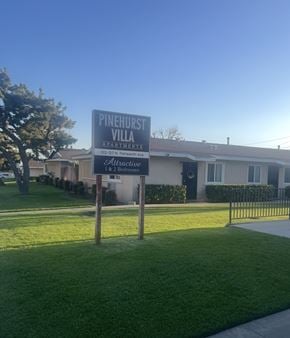 Upland multi-family for rent - A sign for Pinehurst Villa Apartments stands in front of a building.