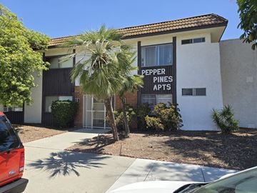 Bellflower multi-family for rent - A Pepper Pines Apts sign is on the front of a building.