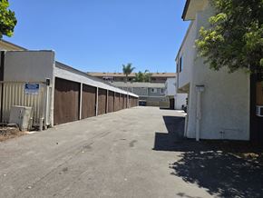 Bellflower multi-family for rent - A parking lot with a blue sign on the left side.