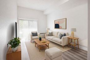 El Monte multi-family for rent - A living room with a white couch, a wooden coffee table, and a potted plant.