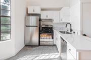 Tujunga multi-family for rent - A modern kitchen with white cabinets and a stainless steel refrigerator.