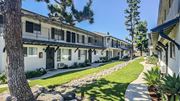 Temple City multi-family for rent - A row of white buildings with balconies and windows are lined up on a sunny day.