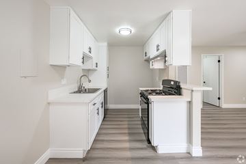 Montebello multi-family for rent - A kitchen with white cabinets and a white island.