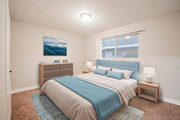 Rialto multi-family for rent - A bedroom with a bed, nightstand, and a painting on the wall.
