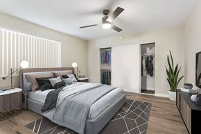 Pomona multi-family for rent - A bedroom with a large bed and a ceiling fan.