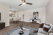 Pomona multi-family for rent - A modern living room with a grey sofa, a coffee table, and a ceiling fan.