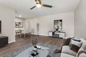 Pomona multi-family for rent - A modern living room with a grey sofa, a coffee table, and a ceiling fan.
