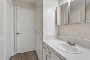Pomona multi-family for rent - A white bathroom with a sink and mirror.