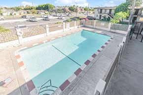 Downey multi-family for rent - A rectangular pool with a white fence around it.