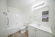Wilmington multi-family for rent - A white bathroom with a toilet, sink, and mirror.