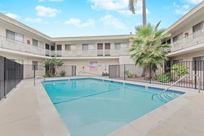 Hawthorne multi-family for rent - A swimming pool in a courtyard surrounded by buildings.