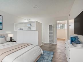 Hawthorne multi-family for rent - A bedroom with a large bed and a TV on the wall.