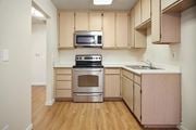 Hemet multi-family for rent - A kitchen with wooden cabinets and a stainless steel stove.