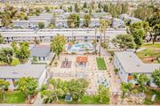 Moreno Valley apartment for rent - A large white building with a pool in the middle of a grassy area.