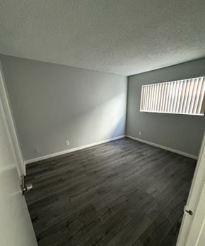 Pomona apartment for rent - A room with wooden flooring and a window with blinds.