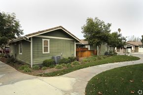 Riverside multi-family for rent - A green house with a brown fence and a grey roof.