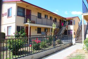 Sun Valley multi-family for rent - A building with a red door and a balcony with a black railing.