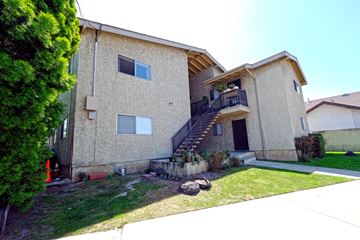 Harbor City multi-family for rent - A tan house with a black door and a balcony.