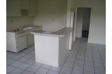 Compton multi-family for rent - A kitchen with white appliances and a white island.