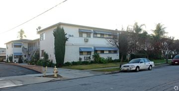Covina multi-family for rent - A white car is parked on the street in front of a house.