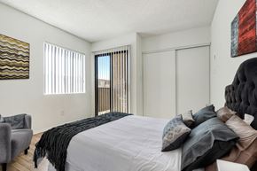 Sylmar multi-family for rent - A bedroom with a large bed and a chair.