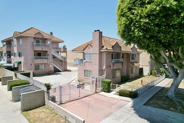 Paramount multi-family for rent - A row of houses with a tree in front of the first house.