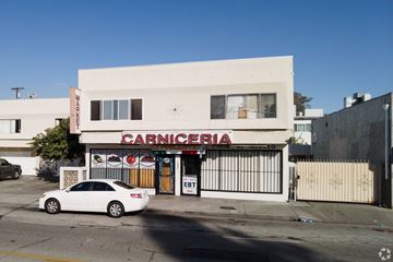 Inglewood apartment for rent - A white car is parked in front of a Carnicería.