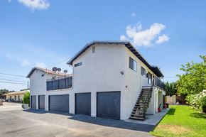 Azusa apartment for rent - A white two-story house with a black roof and a grey garage door.