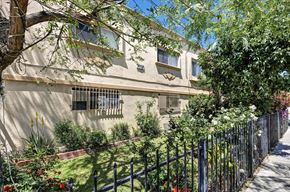 Los Angeles multi-family for rent - A house with a black fence and green plants in front.