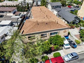 Los Angeles multi-family for rent - A house with a brown roof is surrounded by trees and cars.