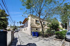 Los Angeles multi-family for rent - A residential street with a house, a tree, and a blue trash can.
