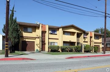 Montebello multi-family for rent - A yellow building with a red roof and a brown garage door.