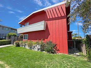 Lynwood multi-family for rent - A red house with a white roof and a green lawn in front.