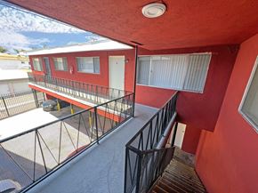 Lynwood multi-family for rent - A red building with a balcony and a black railing.