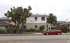 Arcadia multi-family for rent - A red car is parked in front of a white house.