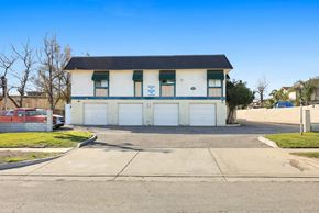 Upland multi-family for rent - A white building with a black roof and a sign on the front.