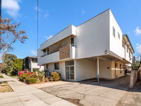 Reseda multi-family for rent - A white modern house with a red car parked in front.