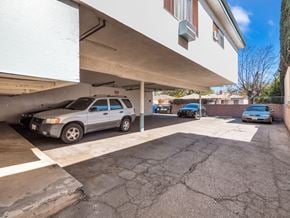 Reseda multi-family for rent - A silver car is parked in a garage under a white building.
