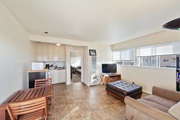 Torrance multi-family for rent - A living room with a brown leather couch and a wooden table.