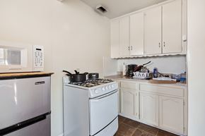 Torrance multi-family for rent - A white stove sits in a kitchen with a white oven and white cabinets.