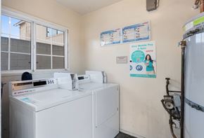 Torrance multi-family for rent - A laundry room with a washer and dryer and a sign on the wall.