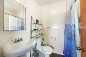 Torrance multi-family for rent - A white sink with a mirror above it and a white toilet behind it.