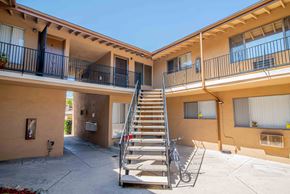Glendale multi-family for rent - A bicycle is parked on a concrete patio in front of a staircase.