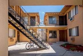 Glendale multi-family for rent - A bicycle is parked on a concrete path in front of a staircase.