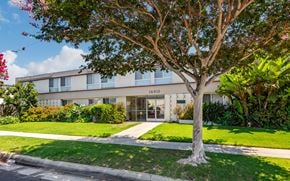 Torrance multi-family for rent - A tree stands in front of a building with the number 1910 on it.