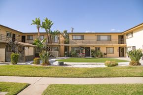 Covina multi-family for rent - A building with a balcony and a tree in front.
