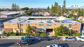 Long Beach multi-family for rent - A parking lot with cars and a building in the background.